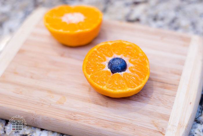 Place a blueberry into half the tangerine