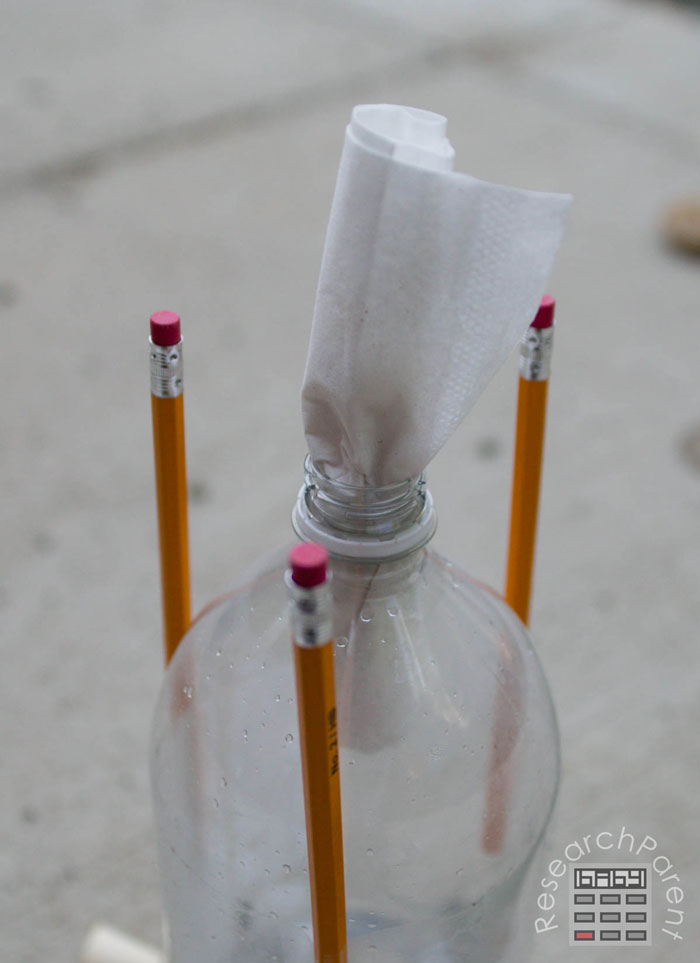 Push tissue packet into 2-liter bottle