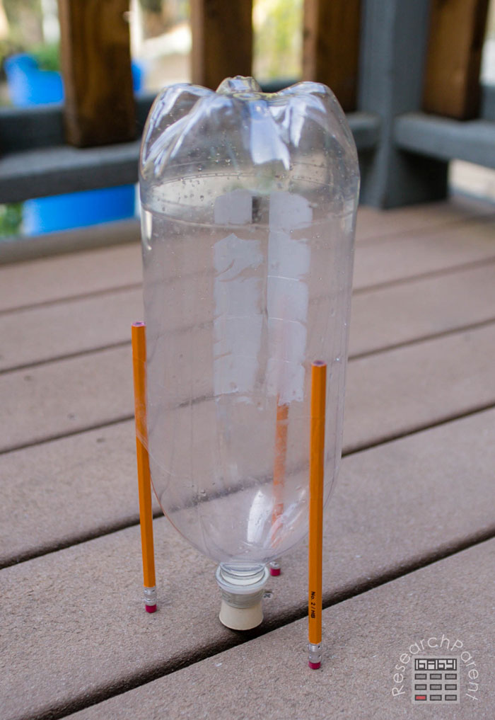 Tape a third pencil to 2-liter bottle
