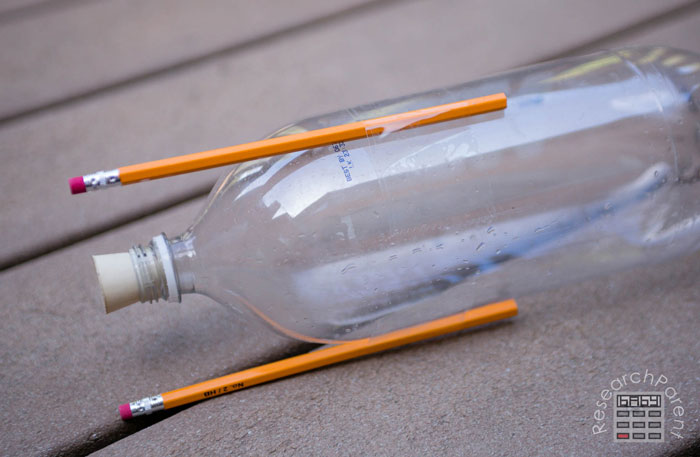 Tape a second pencil to 2-liter bottle